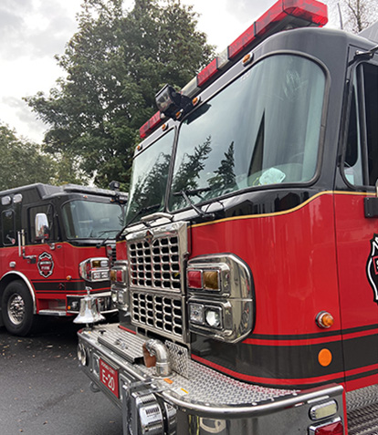 front of a fire engine with another fire engine in the background