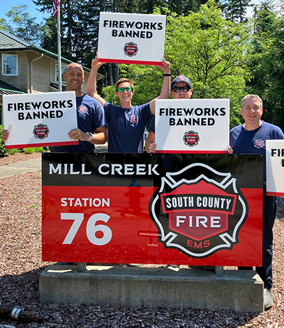 Firefighters holding fireworks ban signs