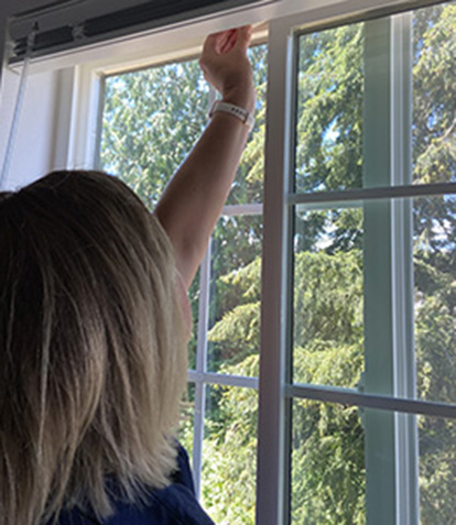 woman installing a window lock to prevent falls